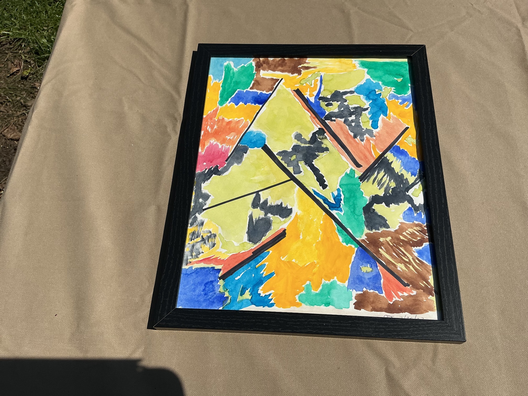 Colourful abstract with black diagonal lines cutting across yellow, blue and green fields