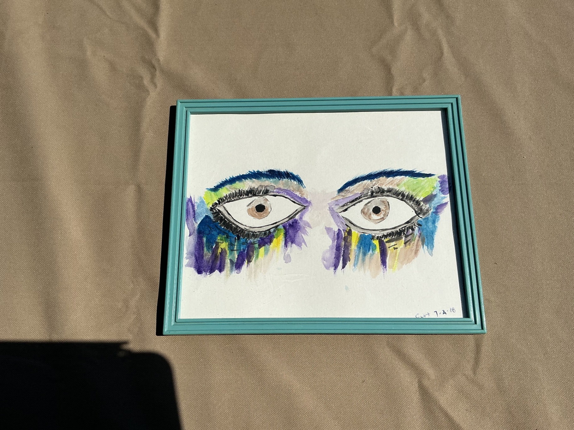Painting of two expressive eyes with violet, blue, and yellow washes
