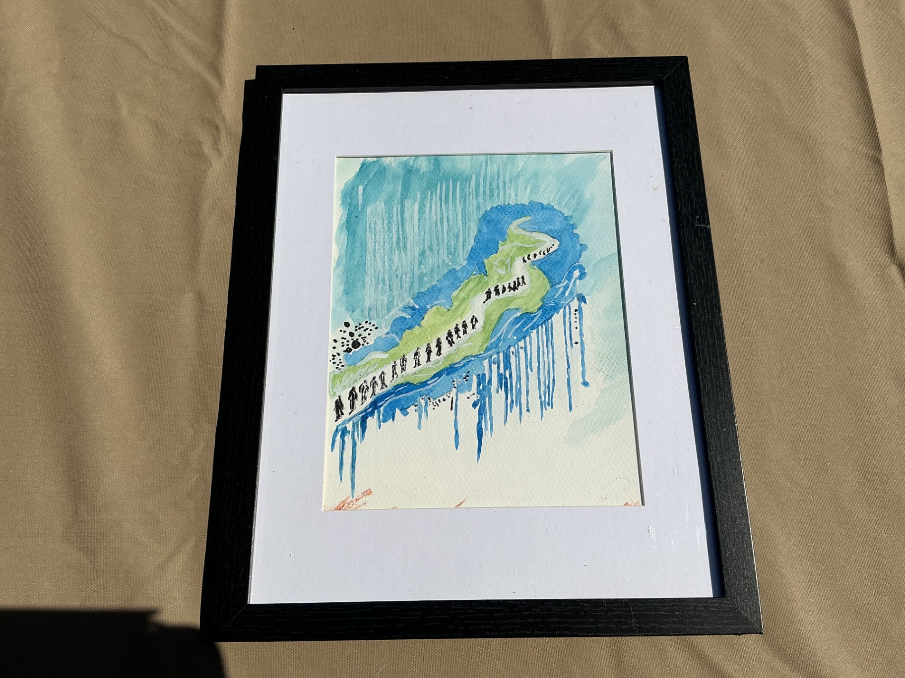 Small framed watercolour of figures ascending a winding green path through blue space