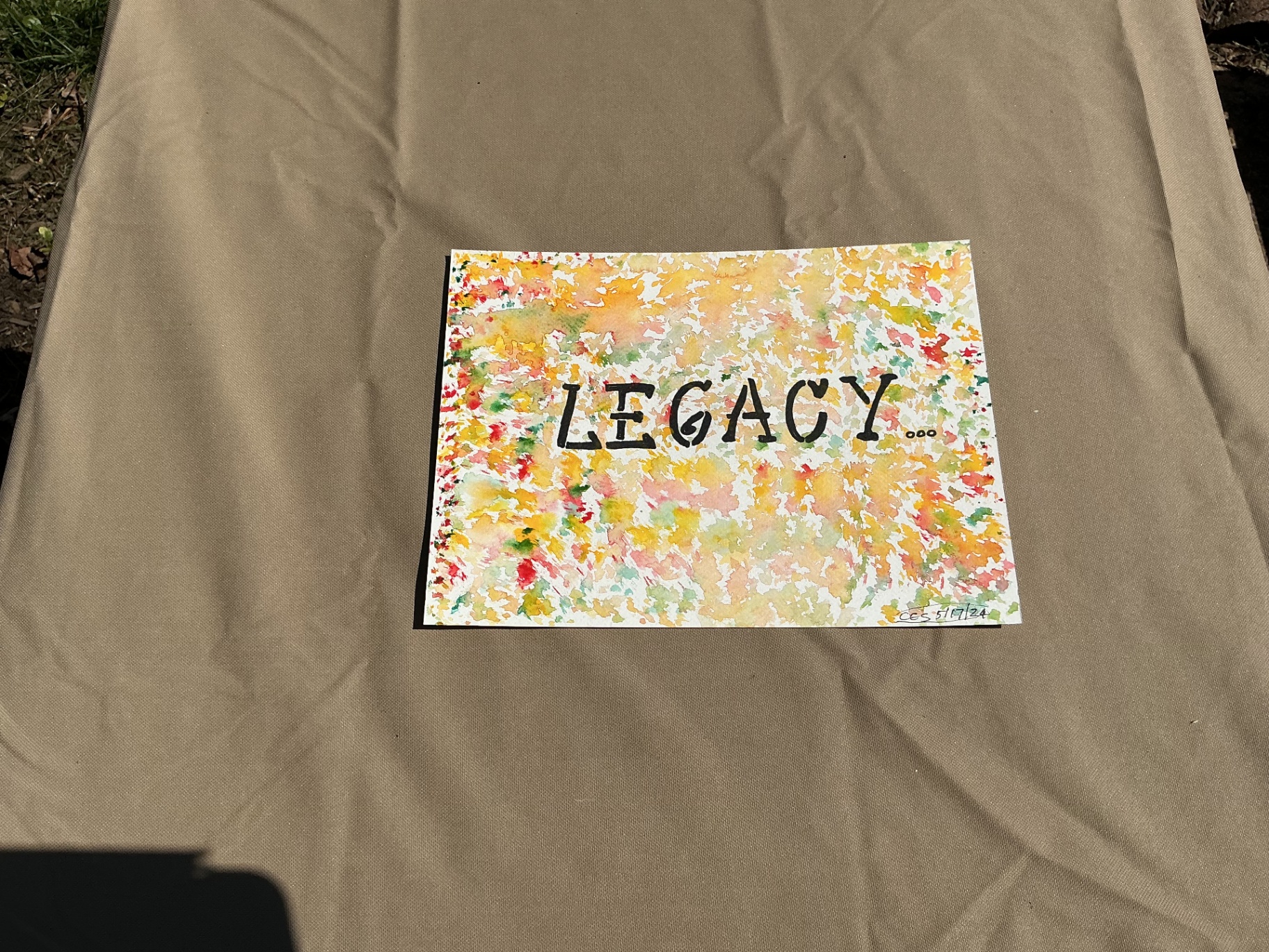 Word Legacy hand-lettered over a warm confetti-like watercolour field